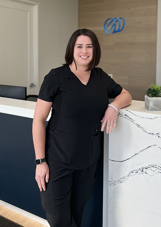 Female staff member leaning on clinic counter