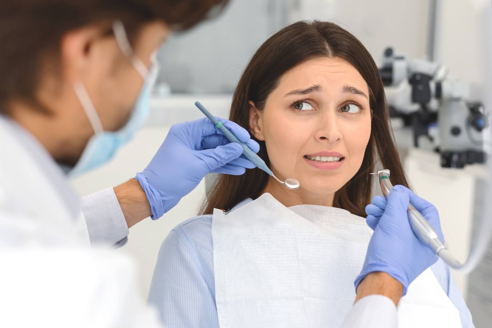 a woman in a dentist chair looking nervous