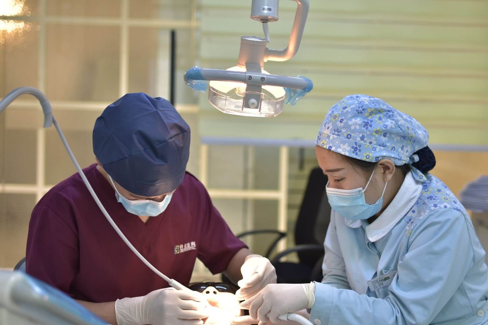 two dentists performing surgery on a patients mouth
