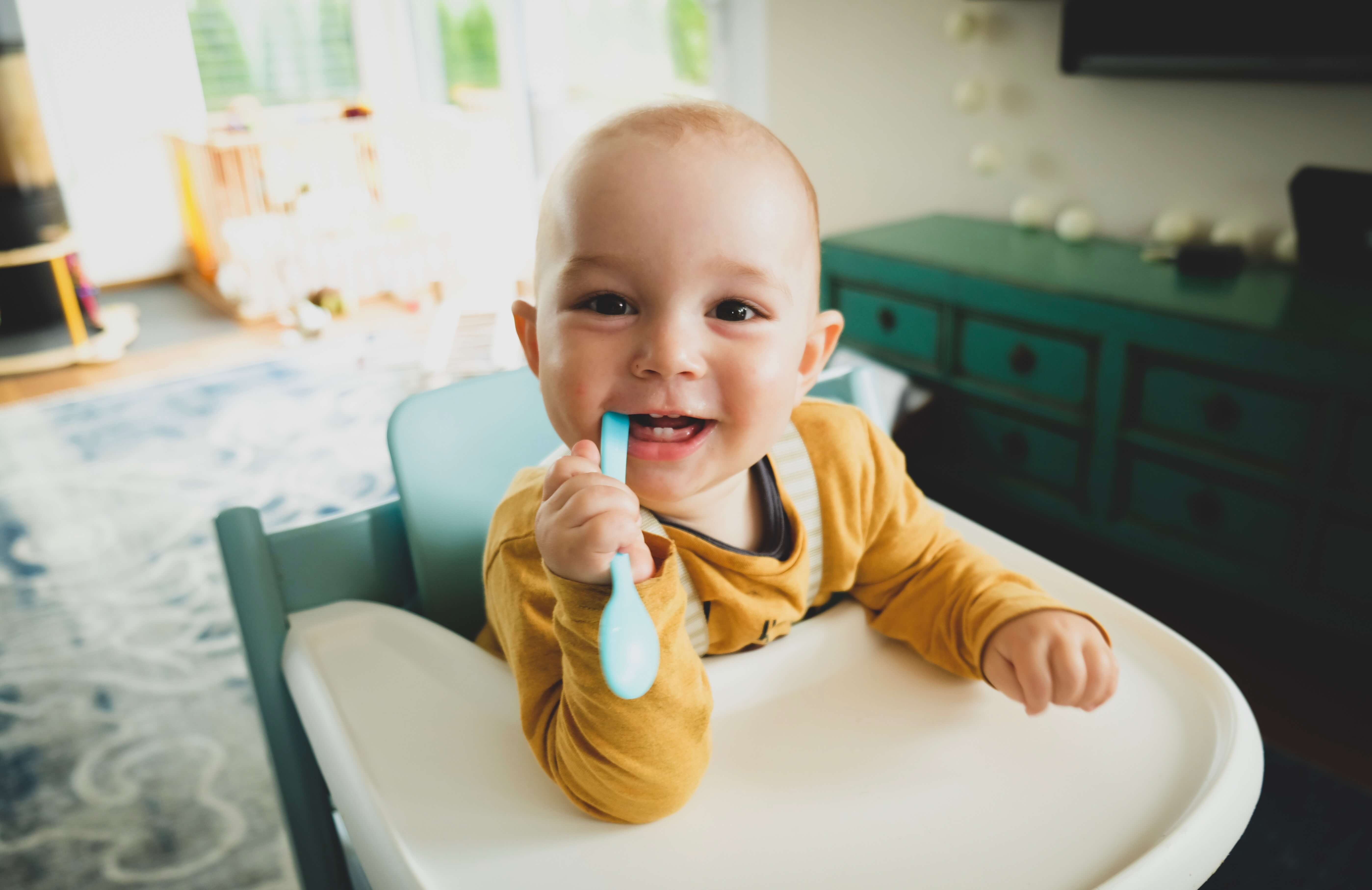 A young child smiling and teething