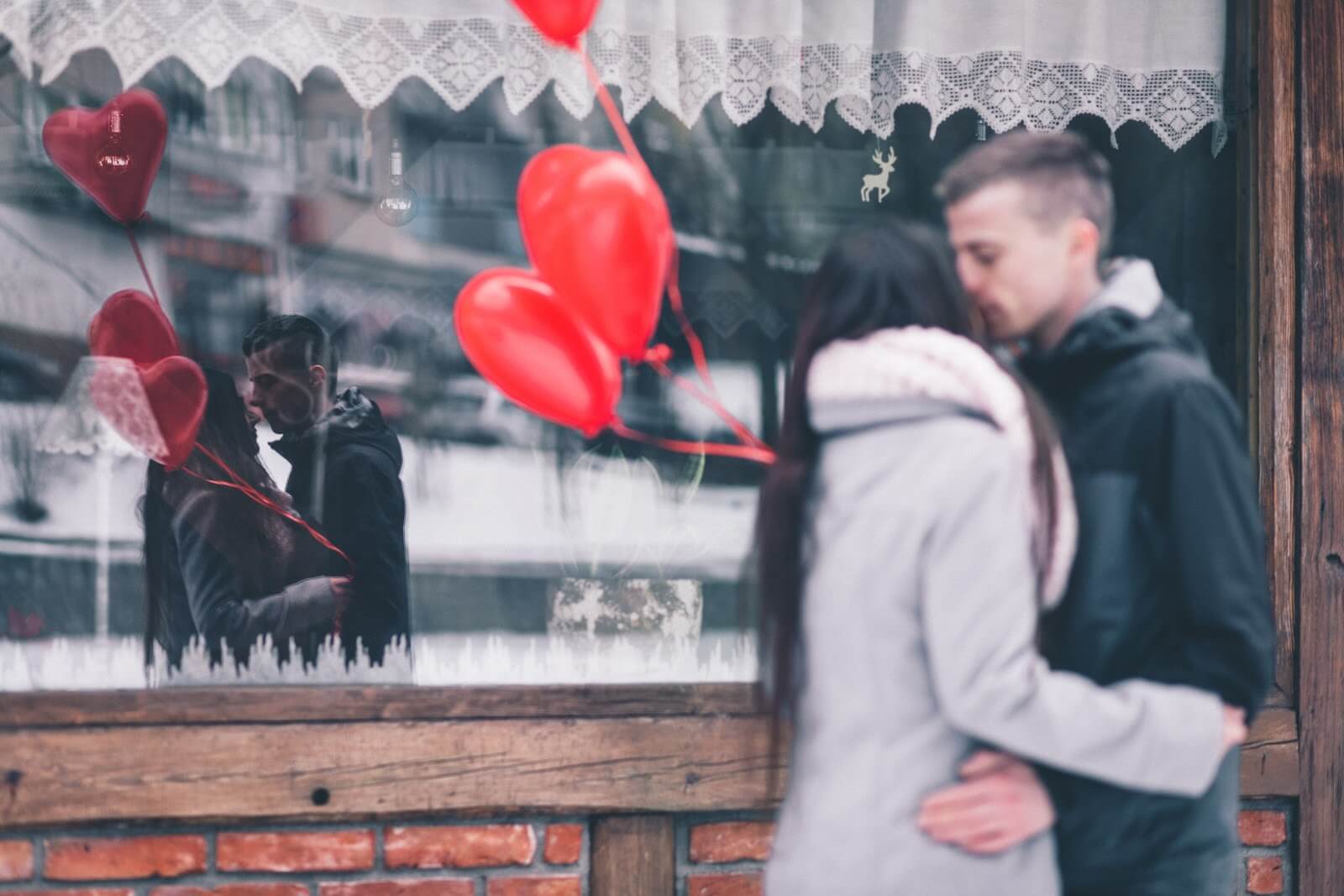 a couple kissing outside a small shop