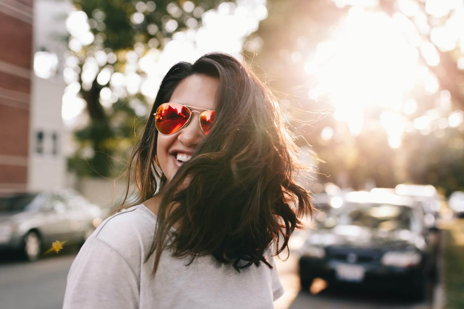 a woman smiling wearing sunglasses
