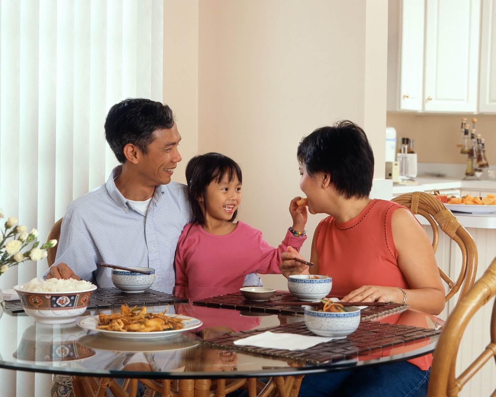 a family of three sitting together at the kitchen table